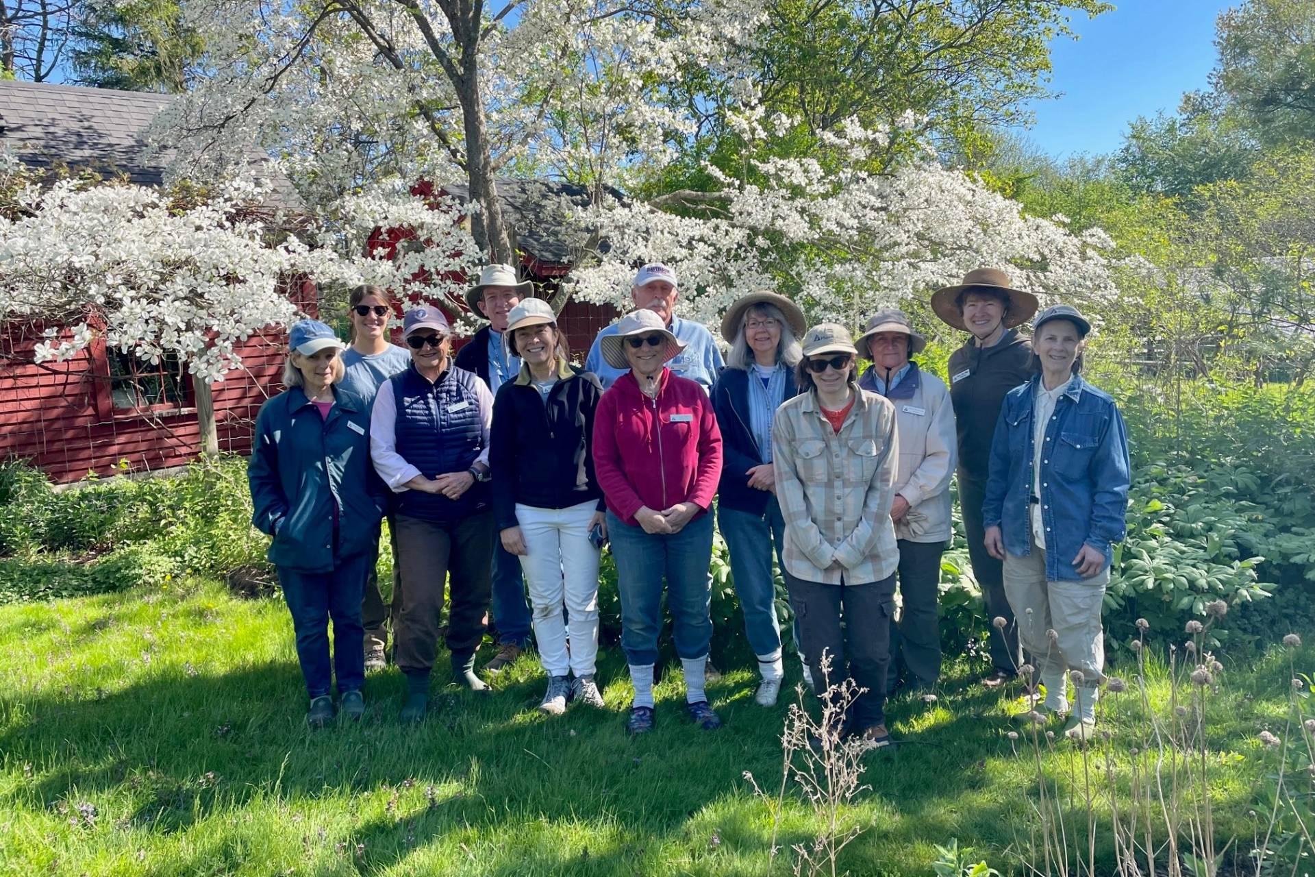 Garden volunteers posed for a group photo in front of a flowering tree