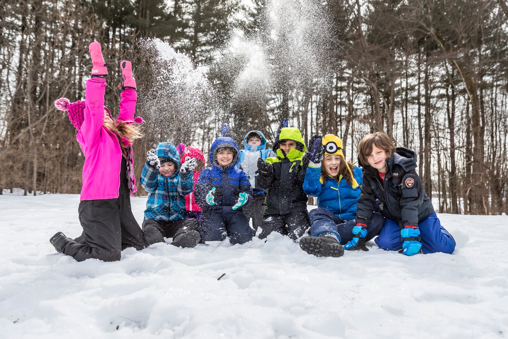 Young children throwing snow into the air