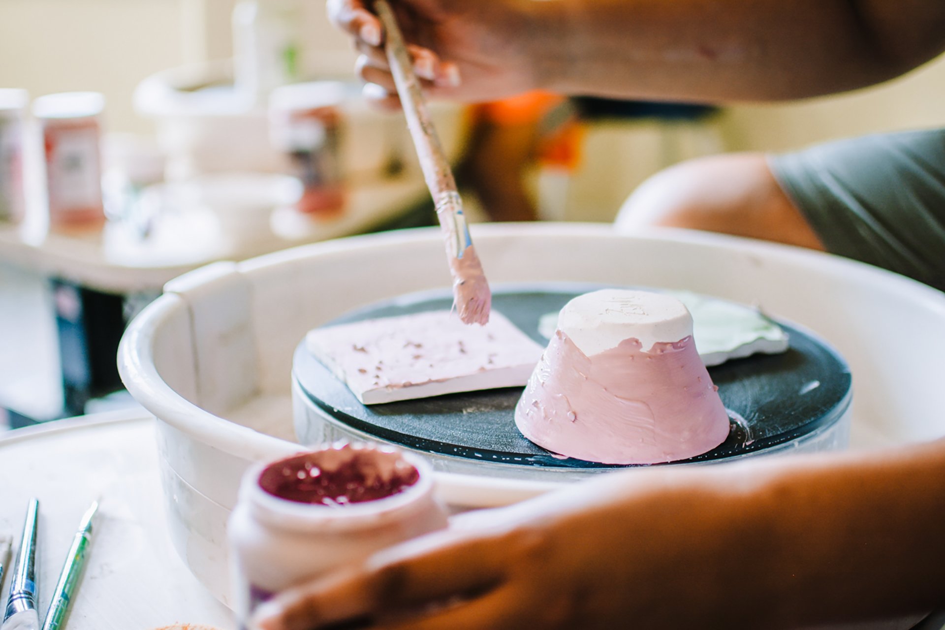 Camper painting ceramics on a pottery wheel