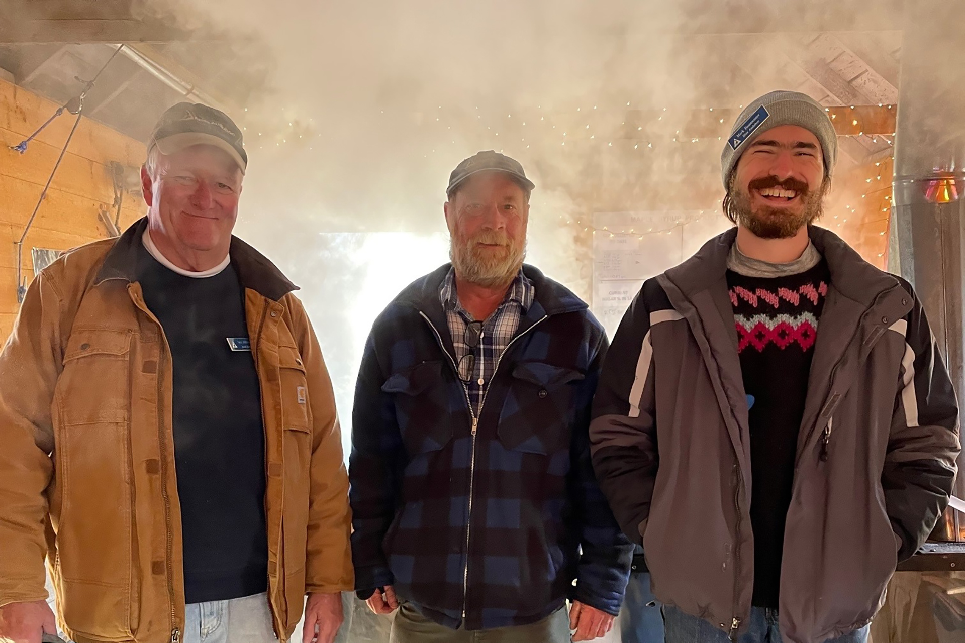 Maple Sugaring: Three men standing in front of a curtain of steam