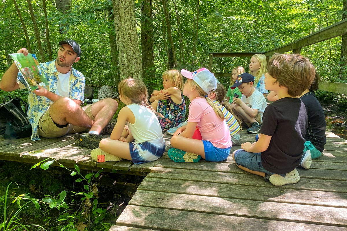 North River Campers on boardwalk reading a book