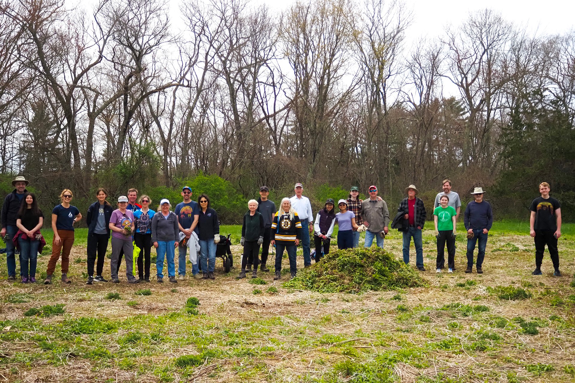 Large group of volunteers posing for a photo in a cleared field