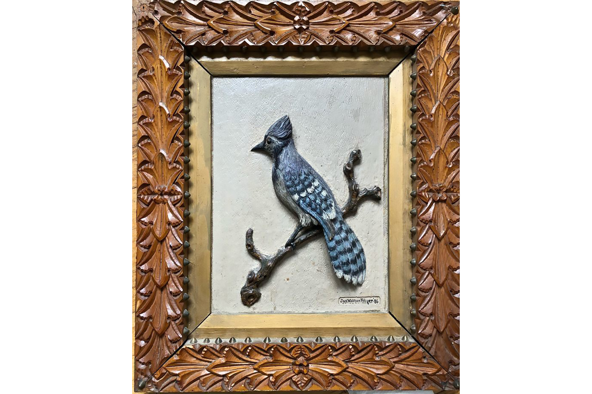 Framed, painted carving of a blue jay in an ornate wooden frame