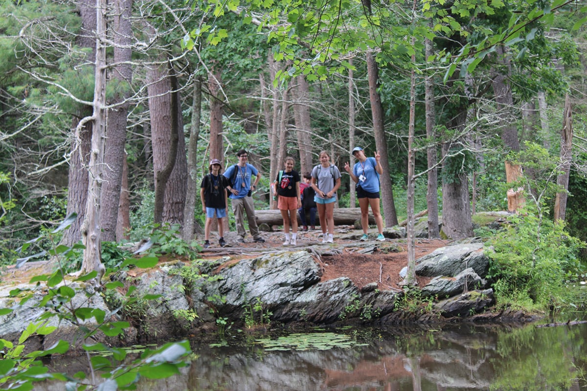 Campers near water standing in a row