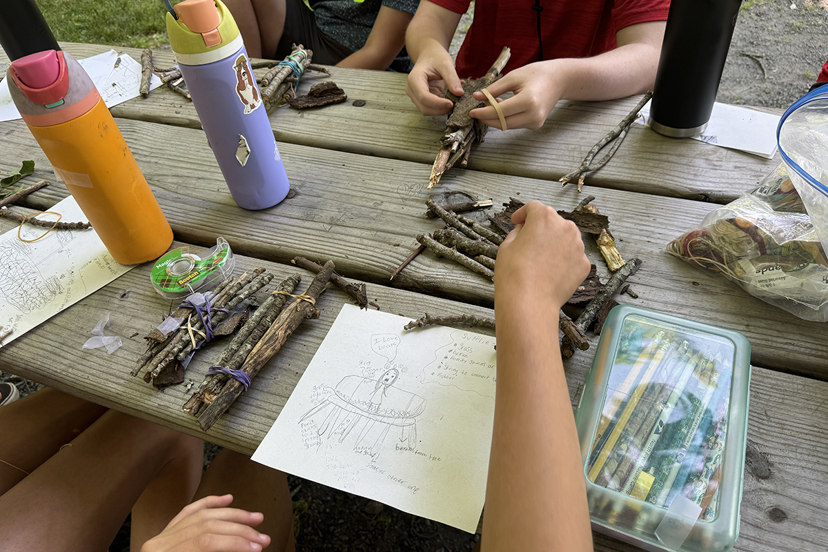 Camper hands bundling sticks together