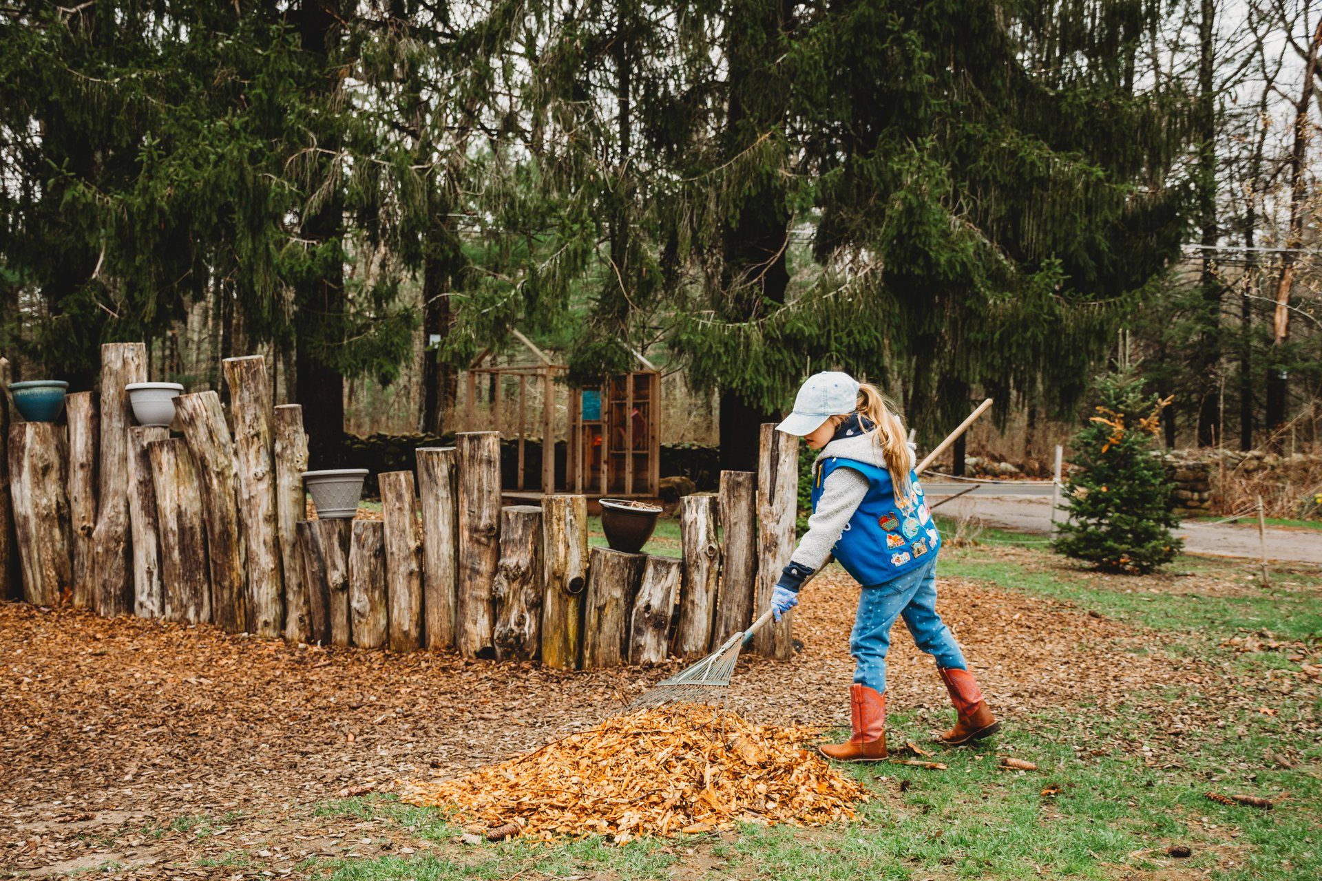 Young child raking leaves into a pile