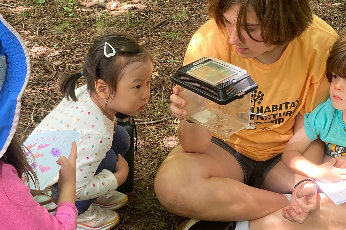 CIT showing younger camper an insect